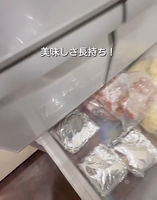 アルミホイルとラップで包んだご飯を冷凍庫に入れる様子