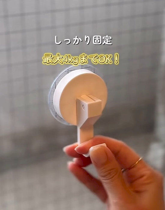 ダイソーのレバー式吸盤フックを窓に取り付けている様子