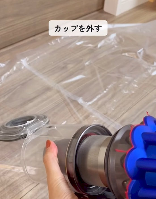 掃除機のダストカップを外している様子