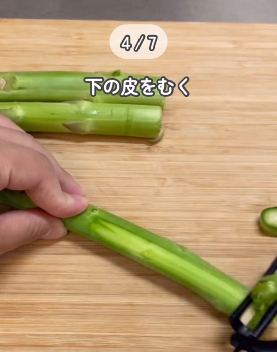 アスパラガスの根元の皮をピーラーでむいている様子