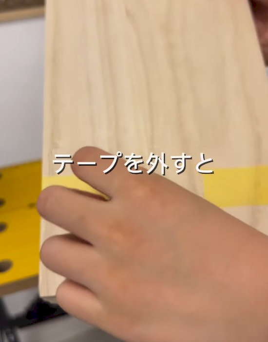 木の板に貼ったテープを外す様子