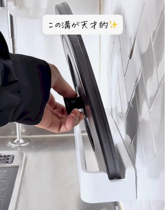 キッチンマルチハンガーに鍋蓋を入れる様子