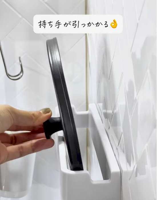 キッチンマルチハンガーに鍋蓋を入れる様子