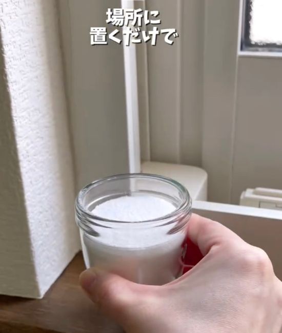 重曹を入れた小瓶を窓際に置く様子