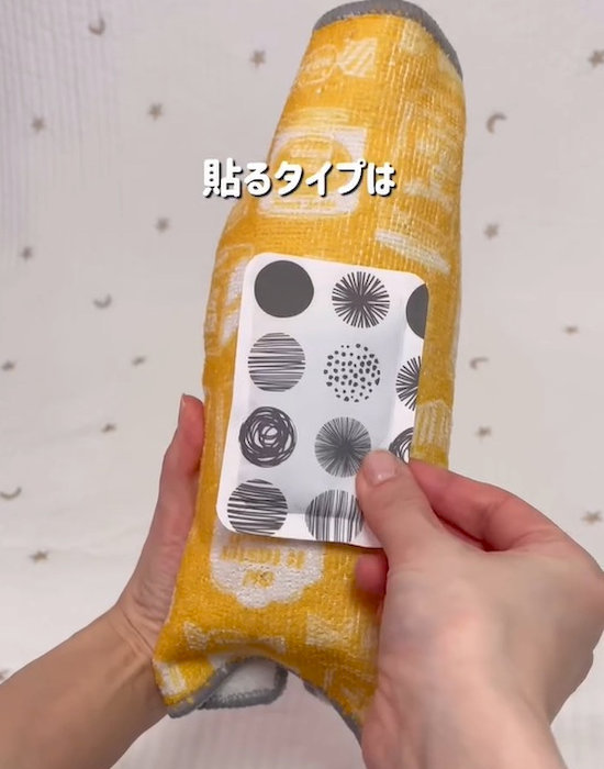 タオルの上から貼るタイプのカイロを貼っている様子