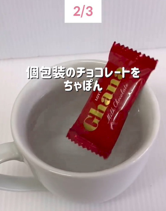 お湯が入ったマグカップに個包装のチョコレートを入れている様子