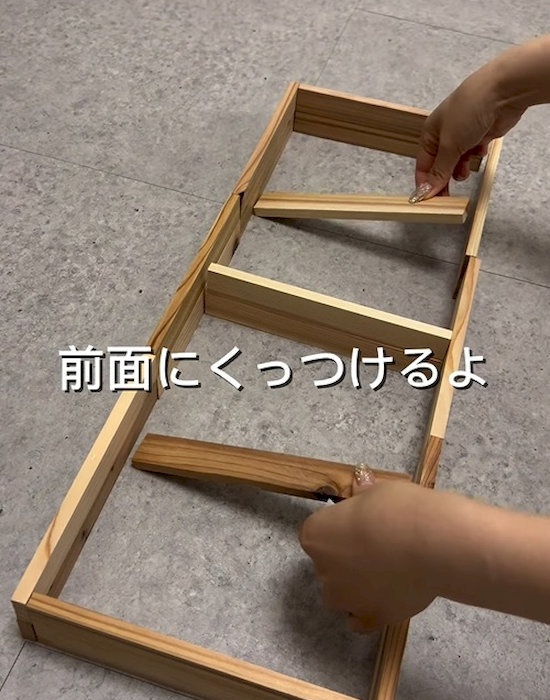 箱型に並べた杉の焚き付け材の中に板材を置く様子