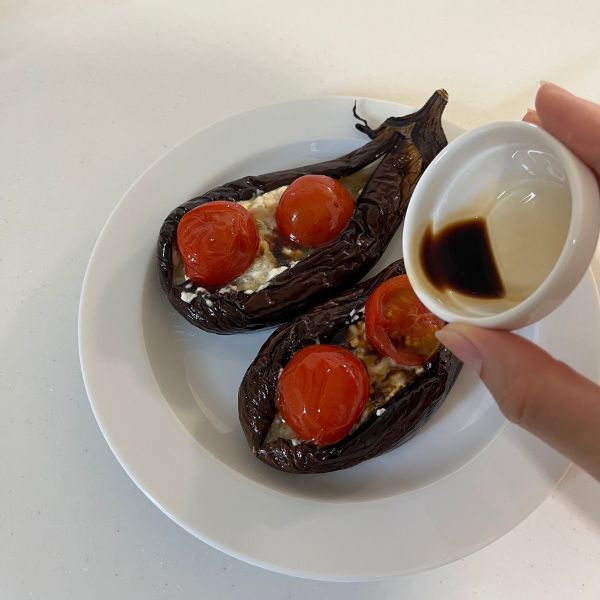 皿に盛り付けた『とろとろナスのチーズ混ぜ』に醤油をかける様子