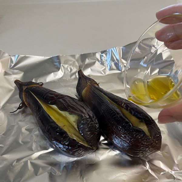 オーブントースターで焼いている途中でナスを取り出してオリーブオイルをかける様子