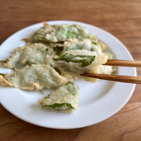 半分に切った『大葉のクリームチーズ揚げ』を箸で持ち上げた様子
