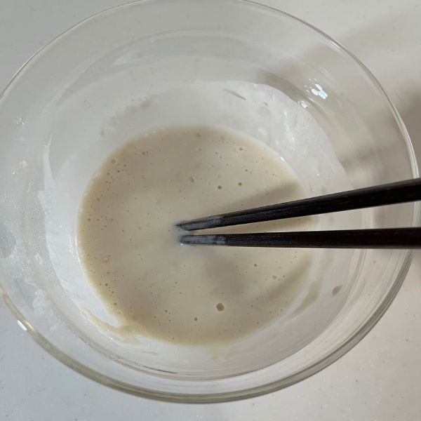 器に入れた衣の材料を箸で混ぜ合わせる様子