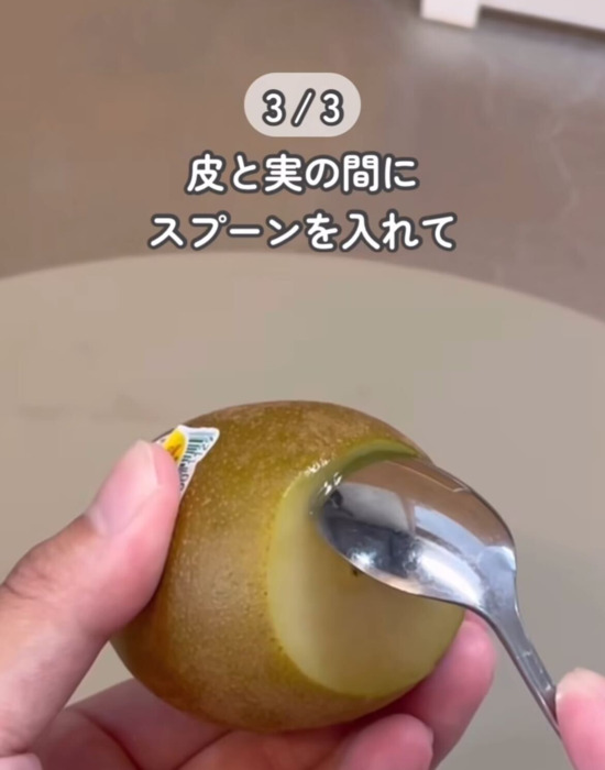 スプーンでキウイの皮をむいている様子