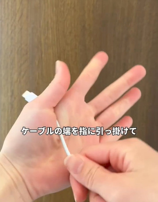 ケーブルの端を指に引っ掛ける様子
