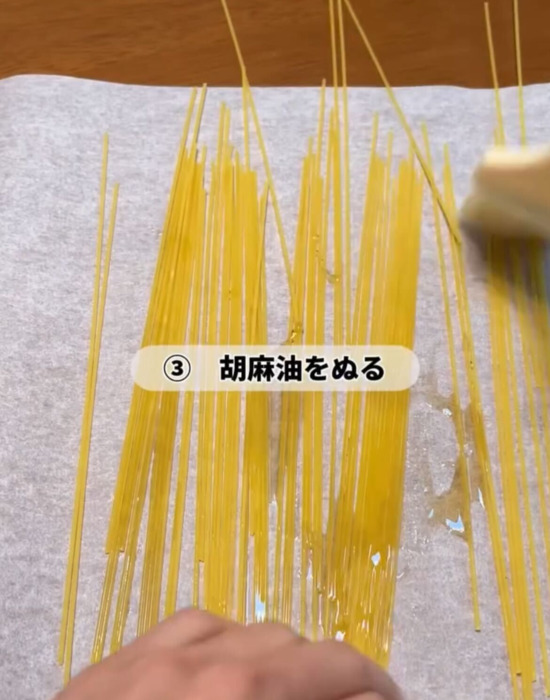 乾燥パスタをごま油を塗っている様子