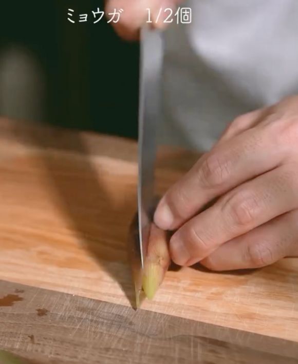 包丁でミョウガを半分に切る様子