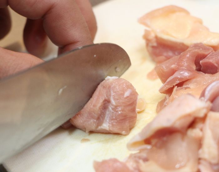鶏肉を包丁で切る様子
