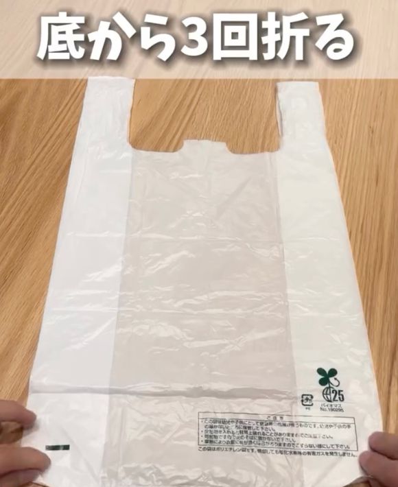 レジ袋を平らに広げて底の部分に手を添えている様子