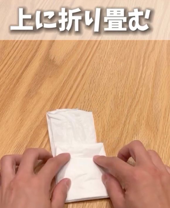 持ち手の部分が少し残る程度まで下から上に向かって折り畳む様子