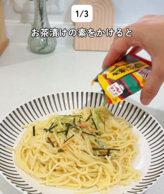 盛り付けたパスタに『お茶づけ海苔』を振りかける様子