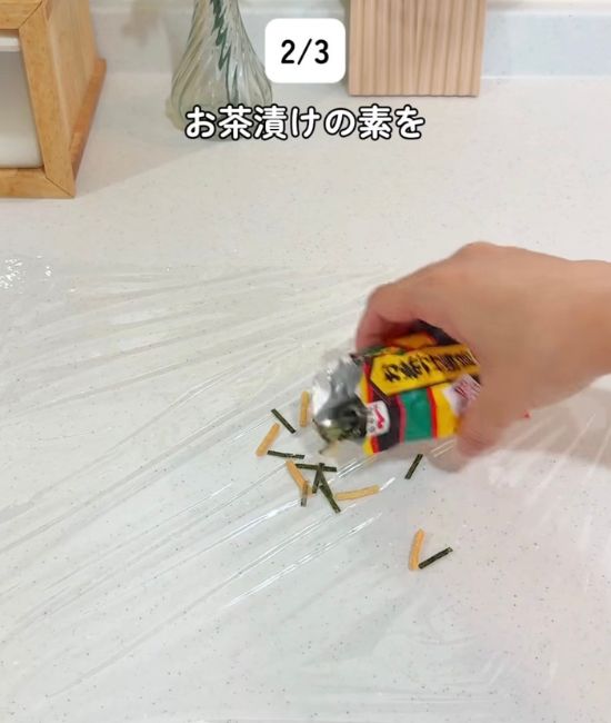 広げたラップの上に『お茶づけ海苔』をかける様子