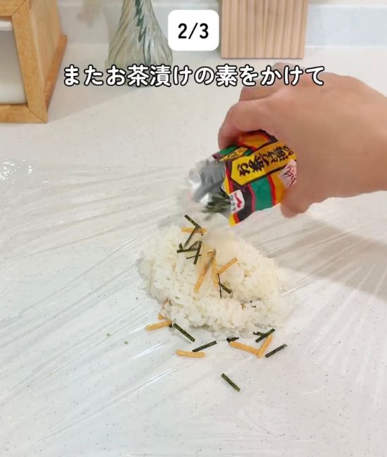 ラップの上にのせたご飯に『お茶づけ海苔』をかける様子