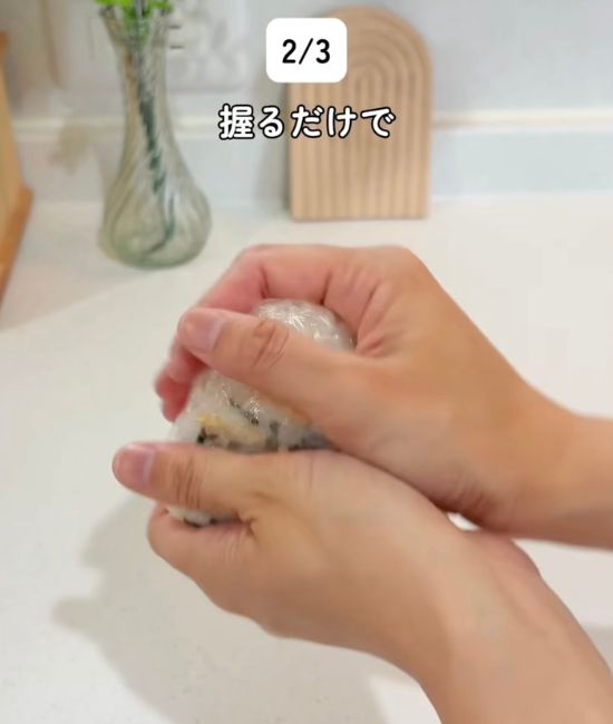 『お茶づけ海苔』を混ぜ合わせたご飯をラップに包んで握る様子