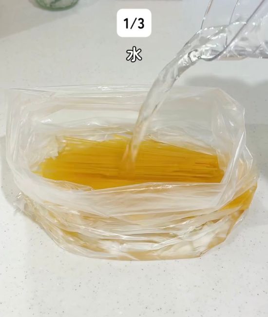 半分に折ったパスタを入れた『アイラップ』に水を注ぐ様子