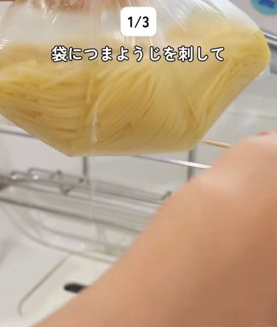 パスタと水を入れて加熱した『アイラップ』の袋につまようじで穴を開ける様子