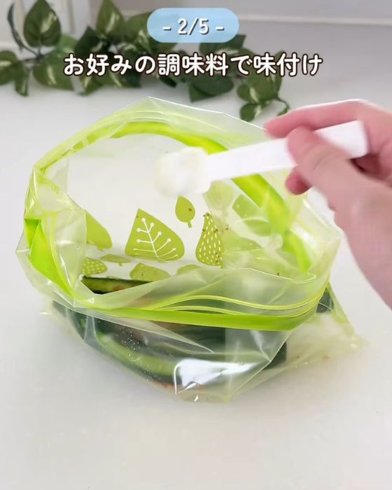 チャック付きの保存袋に冷ましたキュウリと調味料を入れる様子
