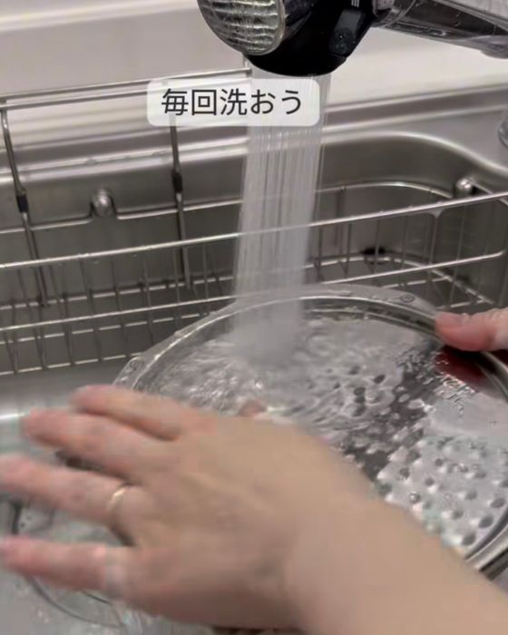 炊飯器の内ぶたを水洗いする様子