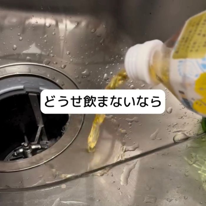 ペットボトルに入った飲み物をシンクに流す様子