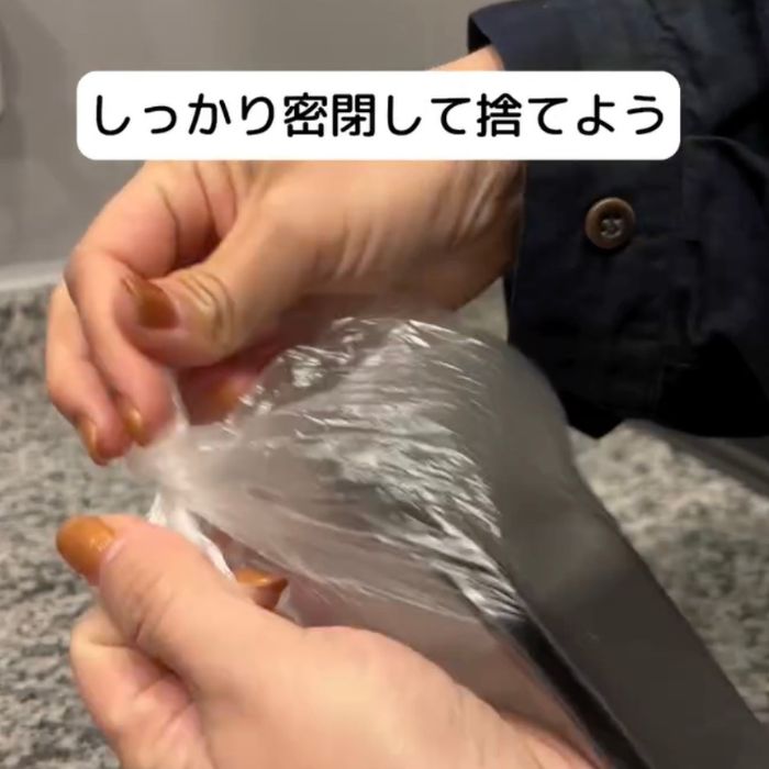 生ゴミを入れたビニール袋の口をしっかりと縛る様子