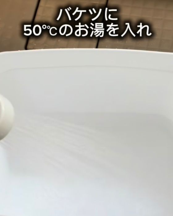 バケツにシャワーでお湯を入れる様子