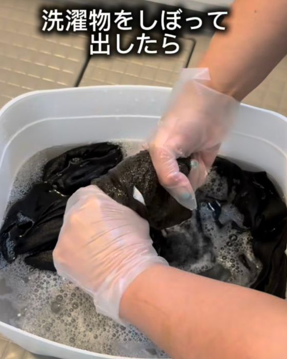 つけおきしていた衣類を取り出して水気を絞る様子