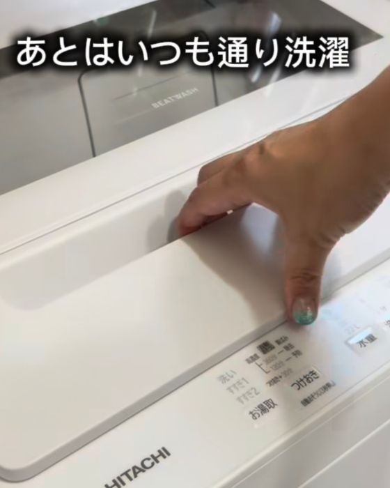 洗濯機の扉に手をかける様子