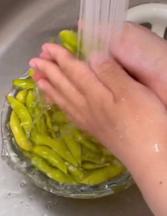 ボウルに入れた枝豆を流水で洗う様子