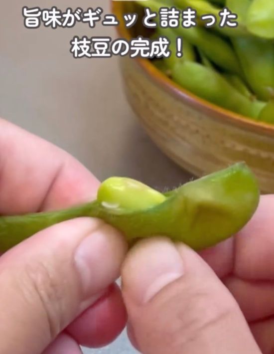 ゆでた枝豆を手で押しだした様子