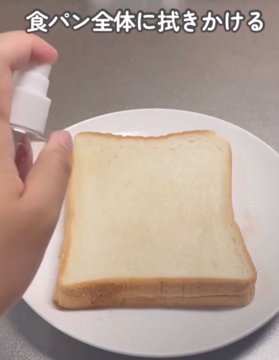 スプレーボトルに入れた麦茶を食パンに吹きかける様子