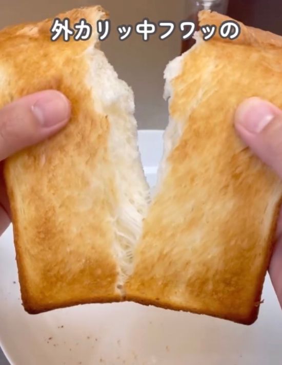 こんがり焼き目が付いた食パンを半分に割く様子
