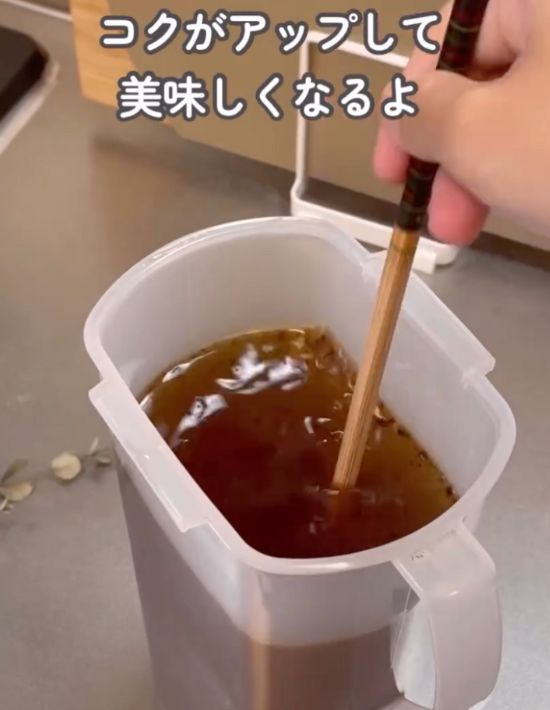 麦茶ポットに作った麦茶にインスタントコーヒーを入れて箸で混ぜる様子