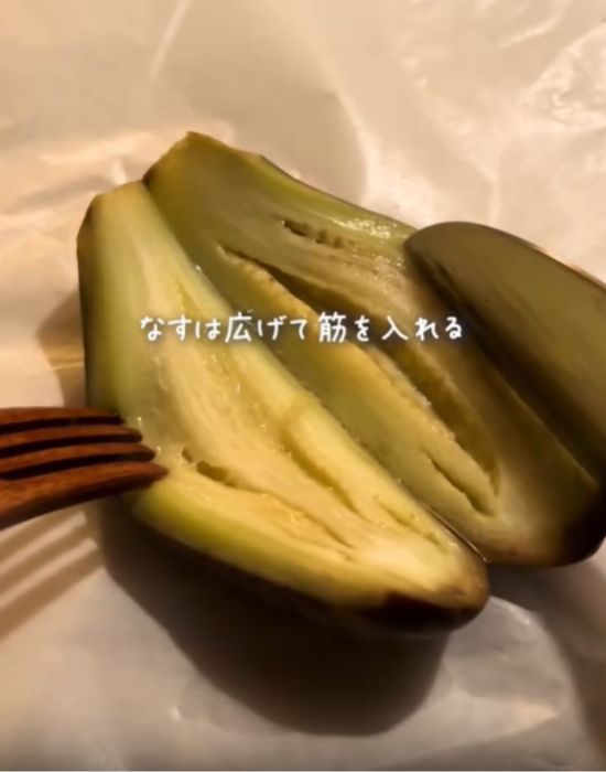 温めたナスを縦半分に切っている様子