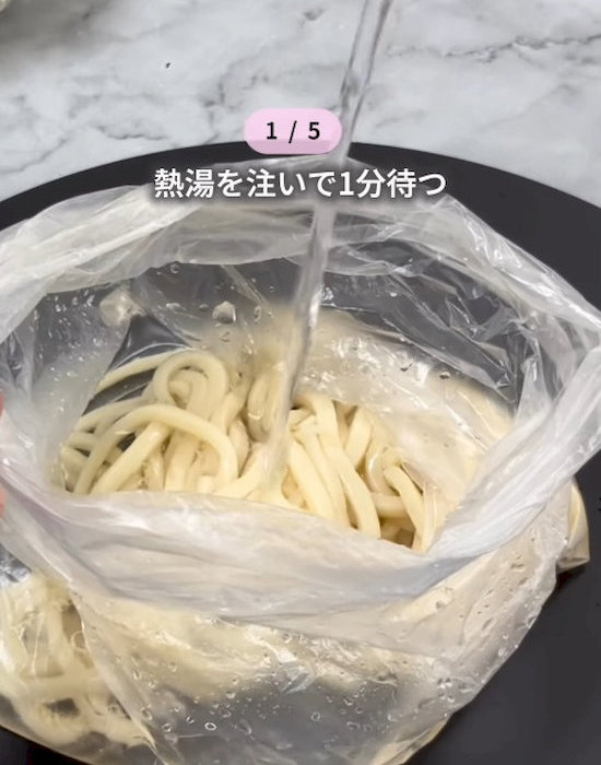 アイラップに入れた冷凍うどんにお湯を注いでいる様子