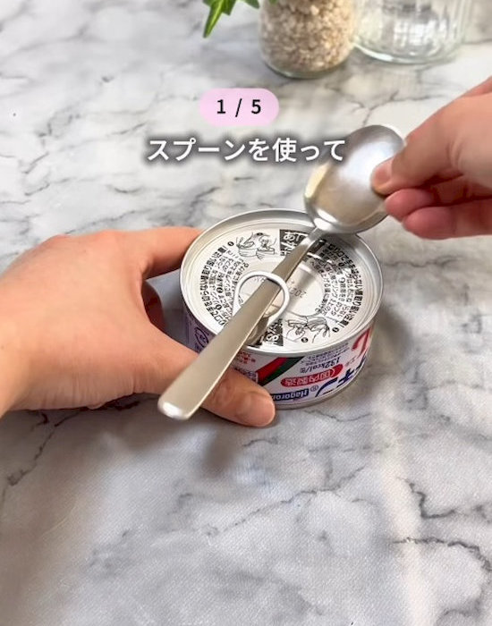 スプーンでツナ缶の蓋を開けている様子