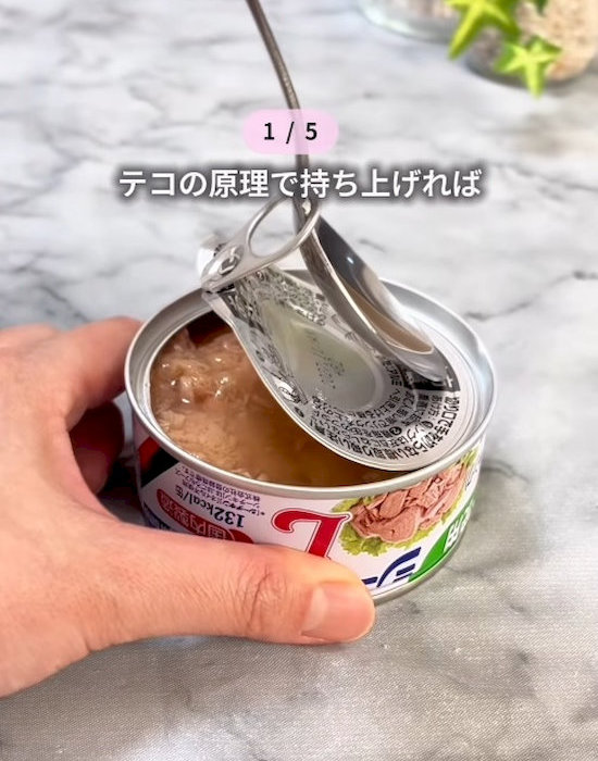 スプーンでツナ缶の蓋を開けている様子