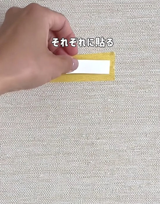 壁にマスキングテープと両面テープを貼っている様子