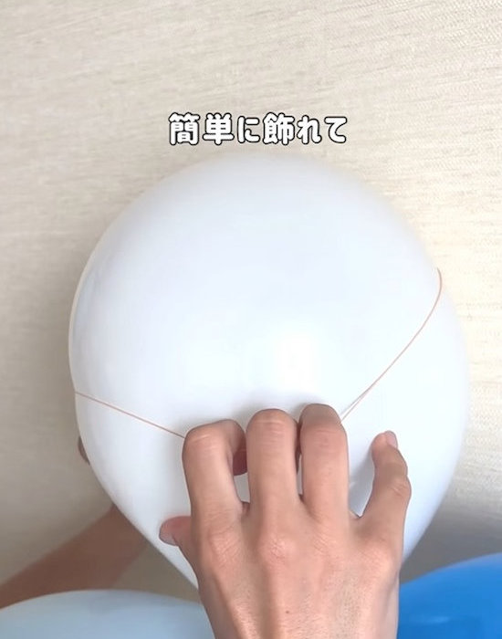 風船に輪ゴムをかけている様子