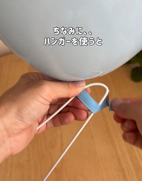 ハンガーを使って風船の口を閉じている様子