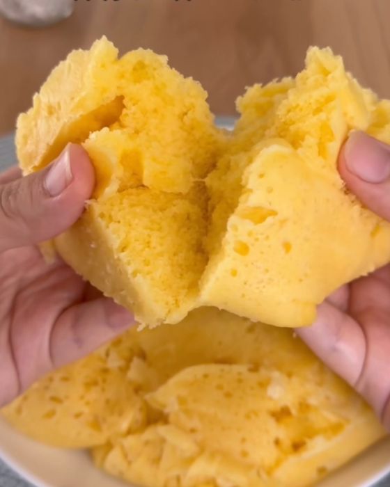 『アイラップ』で作った蒸しパンを袋から取り出して両手で半分に割る様子