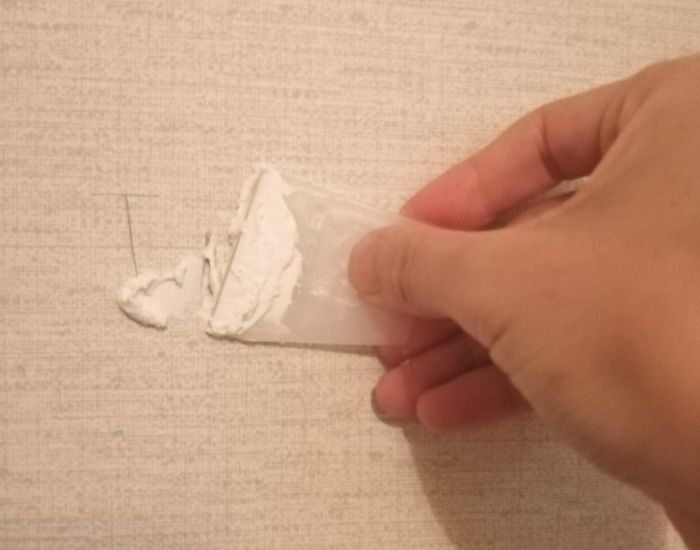 壁にパテを塗る様子