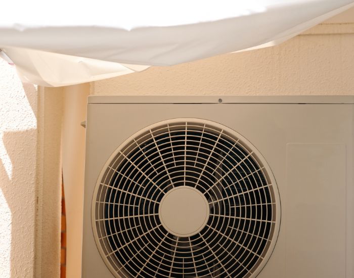 室外機の上に日よけを設置している様子